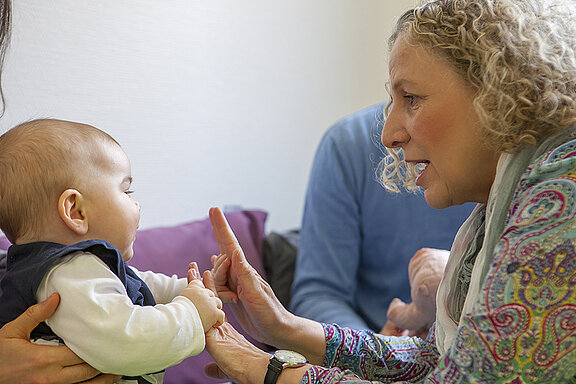 Therapeutin Heike Brosch mit einem Baby und deren Eltern in der Therapiesituation.
