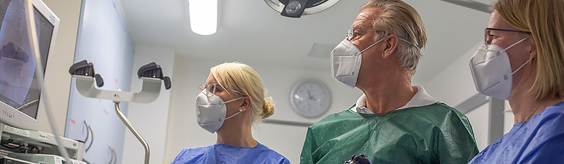 Chefarzt der Klinik für Gastroenterologie und Diabetologie, Dr. med. Ernst-Friedrich Koller und zwei weitere Mitarbeiterinnen des medizinischen Fachpersonals schauen während einer Endoskopie auf den Monitor.