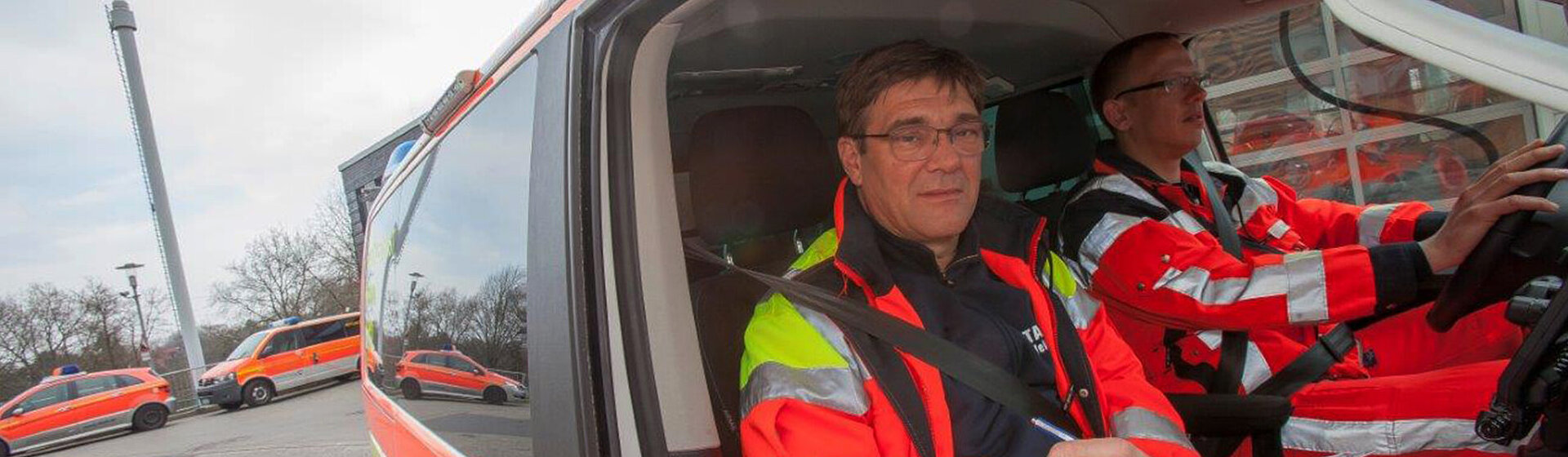Notarzt und Fahrer sitzen im Notarztwagen.