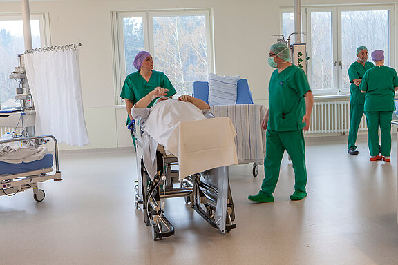 Patient wird vom OP-Team in den Aufwachraum gebracht.