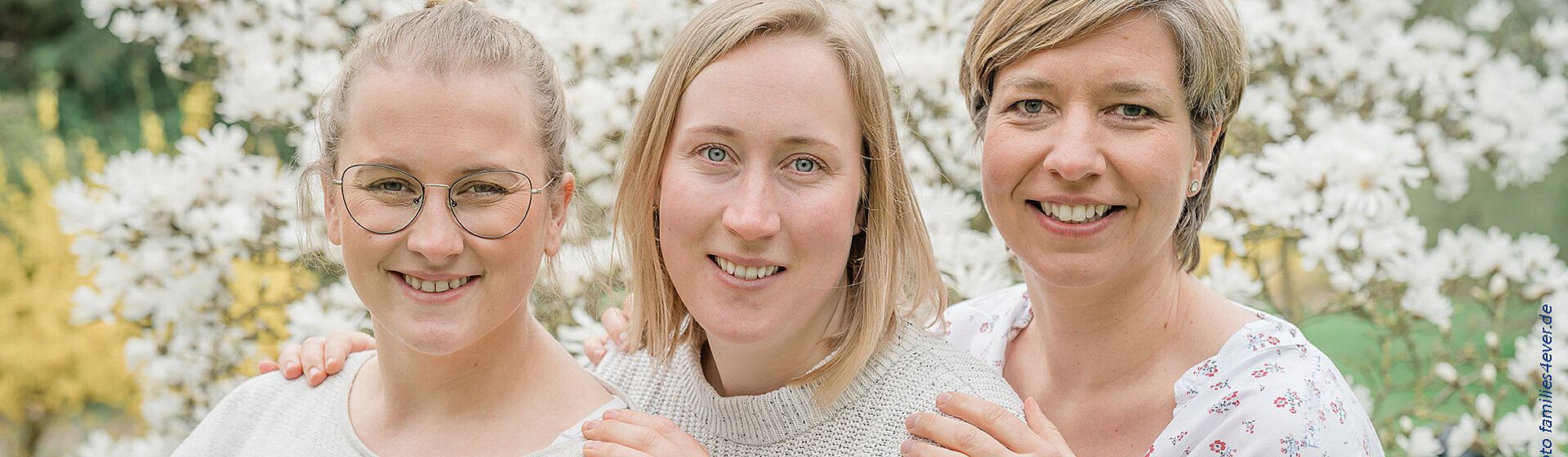 3 Mitarbeiterinnen vom Team der Hebammenpraxis Elmshorn vor einem Magnolienstrauch