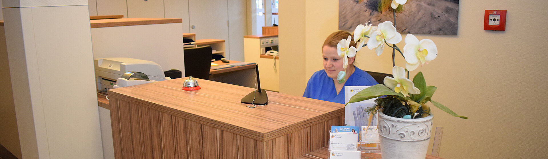 Mitarbeiterin am Empfangstresen 
