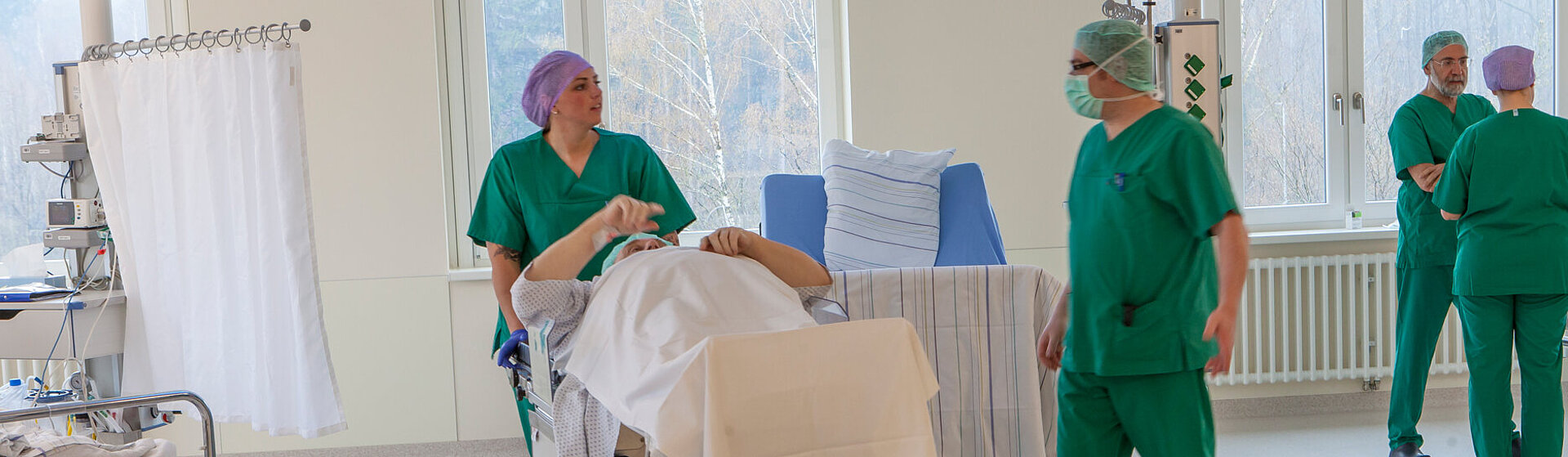 Patient wird vom OP-Team in den Aufwachraum gebracht.