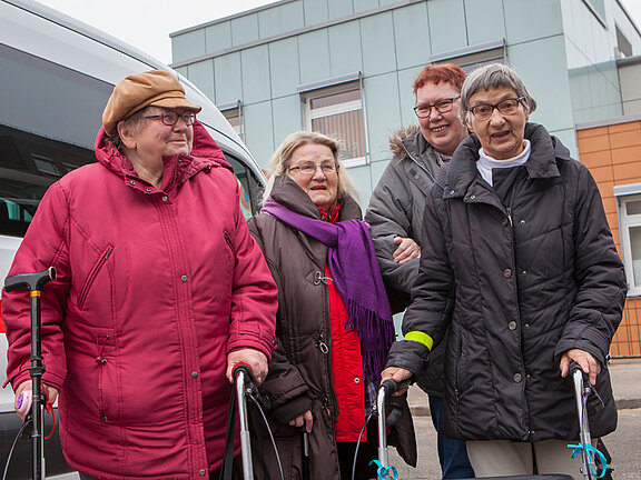 Vier Patientinnen, teilweise mit Gehhilfen, vor der Geriatrischen Tagesklinik