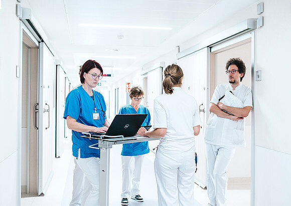 Pflegefachkräfte und Ärzteteam besprechen sich