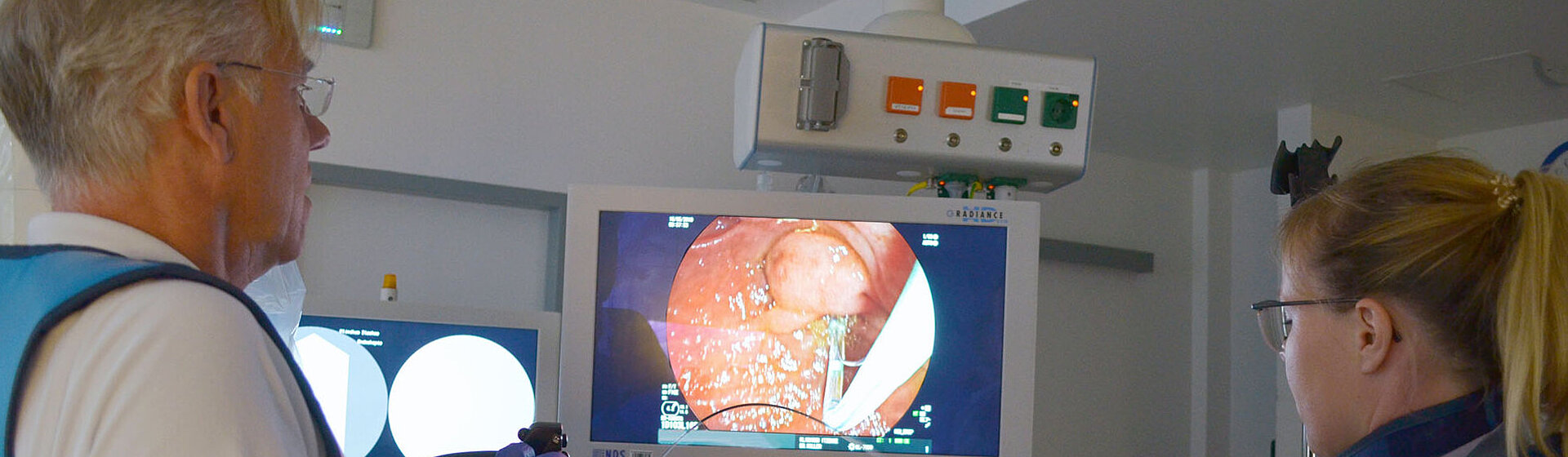 Chefarzt, Dr. med. Ernst-Friedrich Koller, und eine weitere medizinische Fachkollegin stehen im Untersuchungsraum vor dem Monitor. ERCT