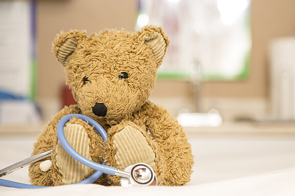 Ein Teddy sitzt und hat ein Stetoskop vor sich.