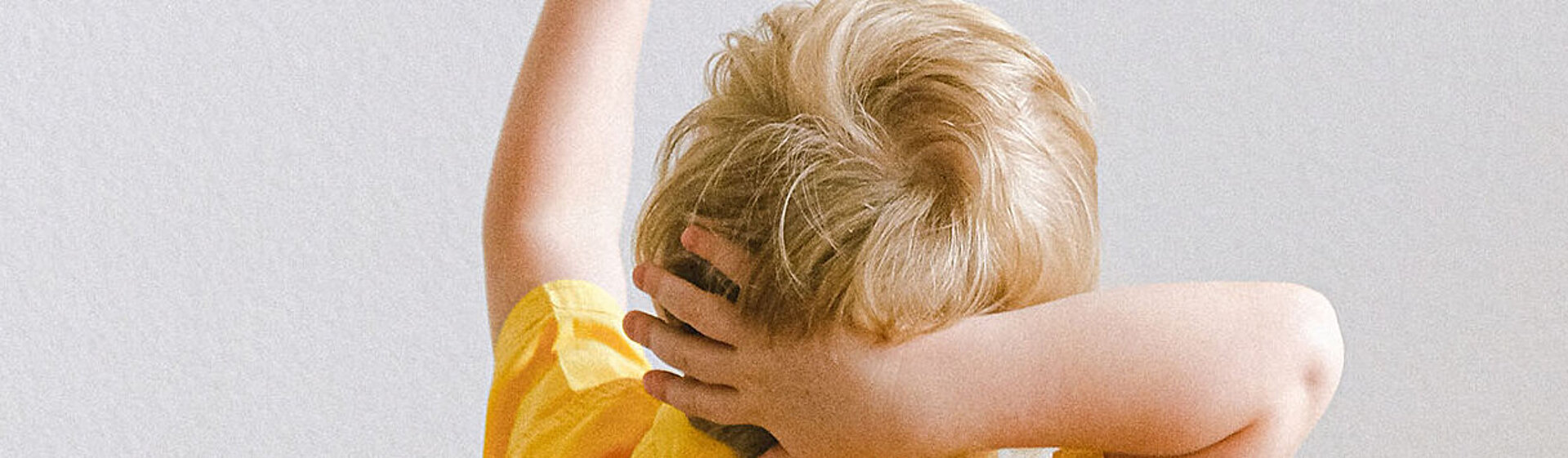 Ein Junge im gelben T-Shirt zeigt nach oben. Ein Junge im gelben T-Shirt zeigt nach oben.