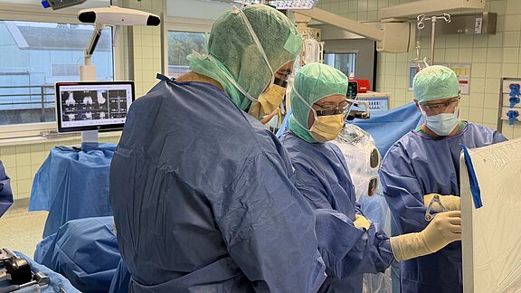 Ärzte im OP analysieren am Monitor Daten