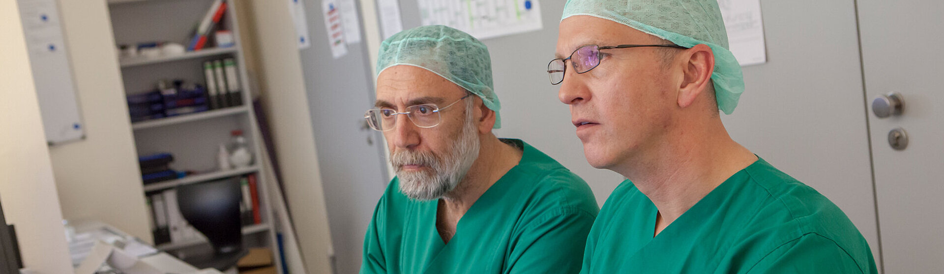 Zwei Operateure der Gefäßmedizin sehen sich Untersuchungsergebnisse am Monitor an.