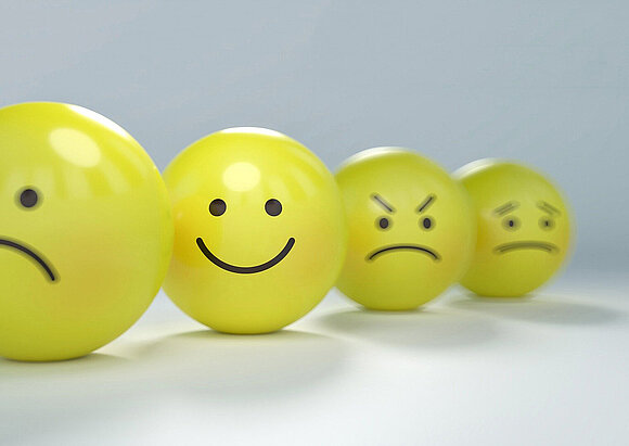 Ethik-Komitee Gelbe Bälle mit Gesichtern in unterschiedlichen Emotionen.