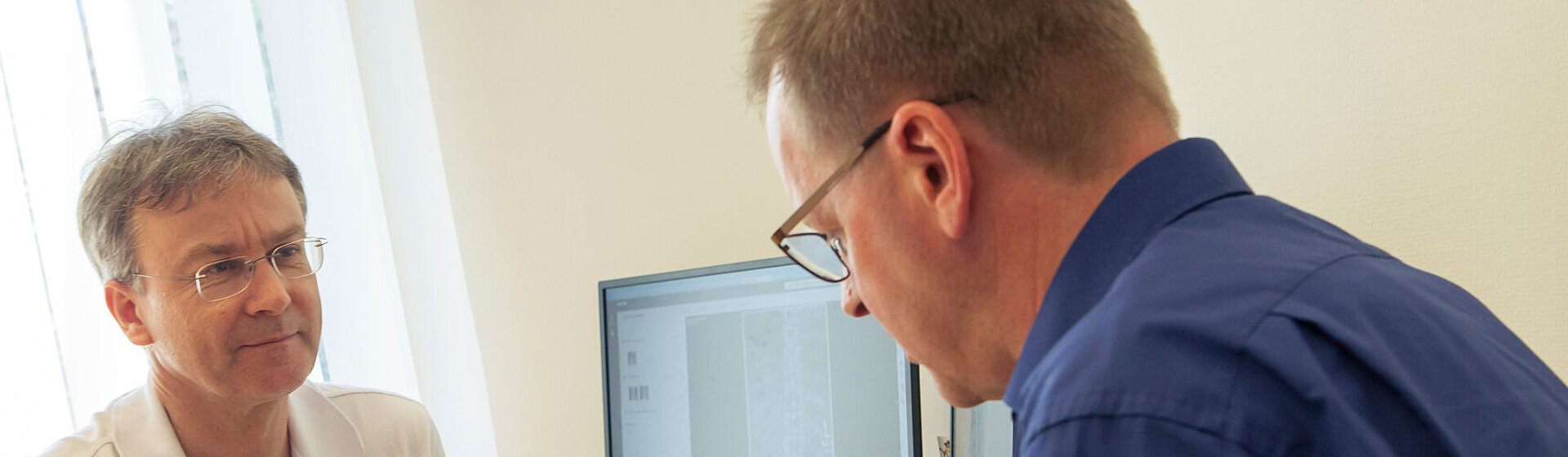 Dr. med. Wolfram Kluge in der Sprechstunde im Gespräch mit einem Patienten.