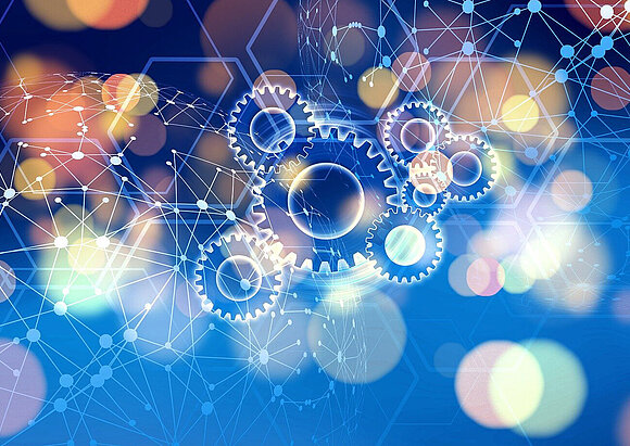 Kooperationen Zahnrädergrafik, im Hintergrund verschwommene bunte Lichter