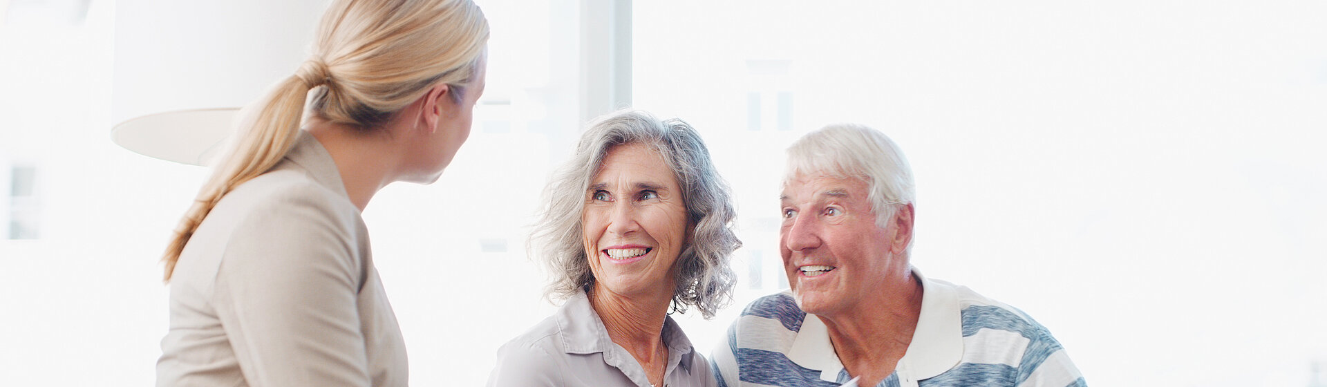 Ein älteres Paar wird von einer Mitarbeiterin beraten.