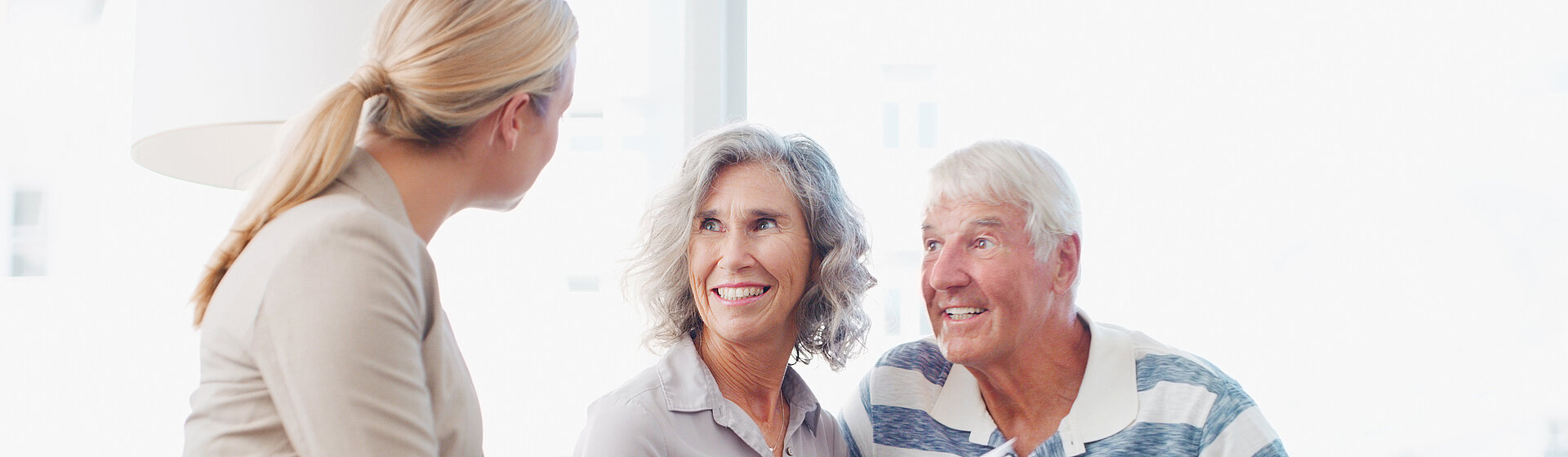 Ein älteres Paar wird von einer Mitarbeiterin beraten. Ein älteres Paar wird von einer Mitarbeiterin beraten.