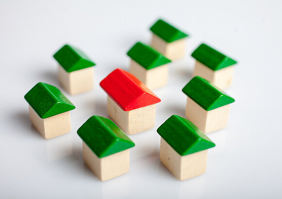 Tochtergesellschaften Spiel-Holzhäuser mit grünen Dächern, in der Mitte eines mit einem roten Dach