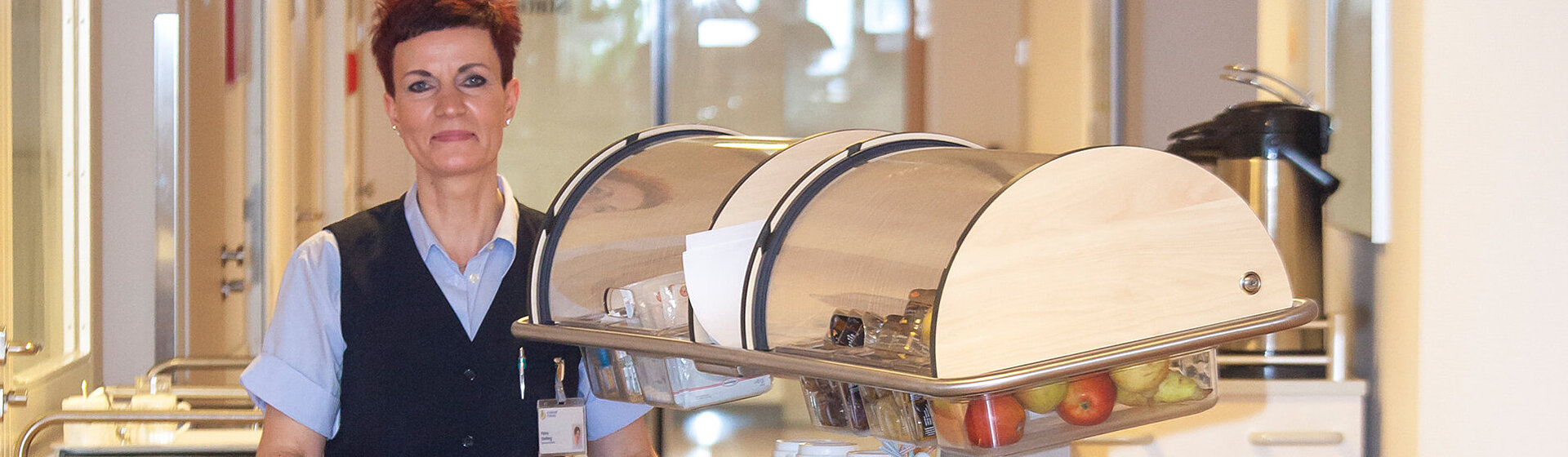 Servicekraft schiebt einen Buffetwagen Servicekraft schiebt einen Buffetwagen