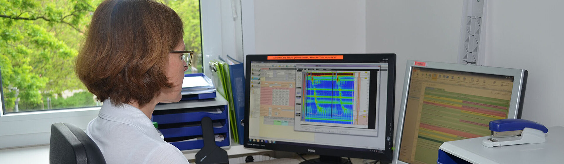 Leitende Ärztin Julia Hirdes-Montigel sitzt am Schreibtisch und schaut auf dem PC und auf das Tablet. Leitende Ärztin Julia Hirdes-Montigel sitzt am Schreibtisch und schaut auf dem PC und auf das Tablet.