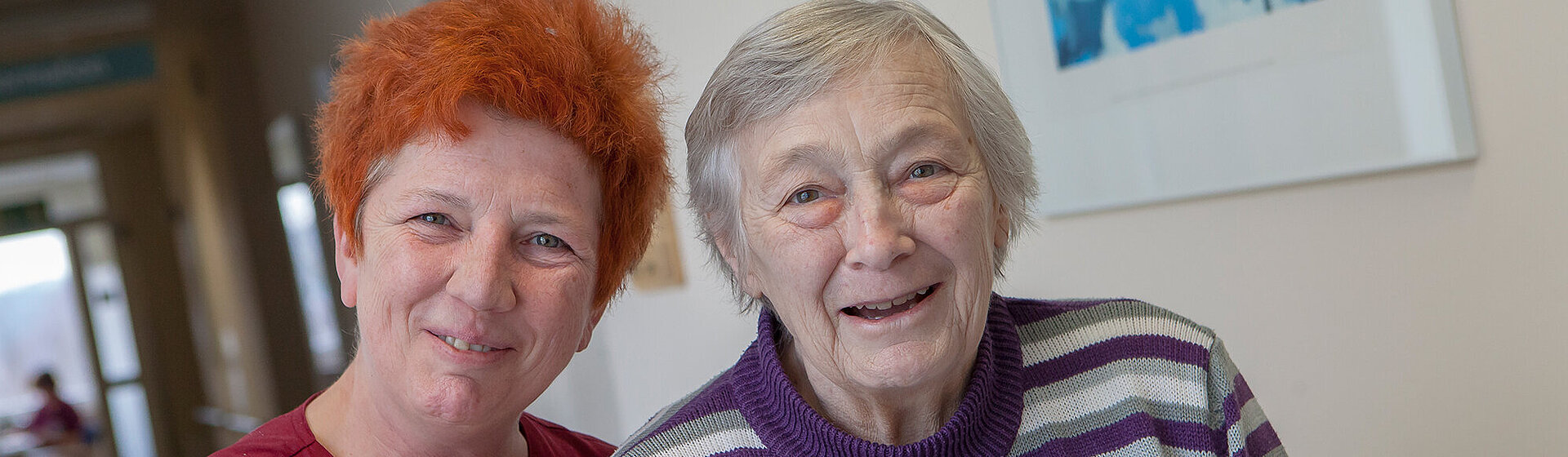 Eine Pflegefachkraft ist mit einer Patientin auf dem Flur der Geriatrischen Tagesklinik unterwegs. Eine Pflegefachkraft ist mit einer Patientin auf dem Flur der Geriatrischen Tagesklinik unterwegs.