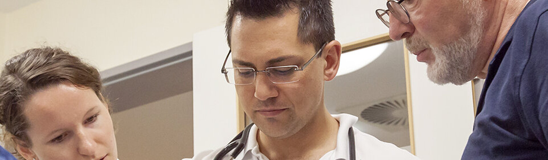 Drei Mediziner schauen sich Untersuchungsberichte an. Drei Mediziner schauen sich Untersuchungsberichte an.