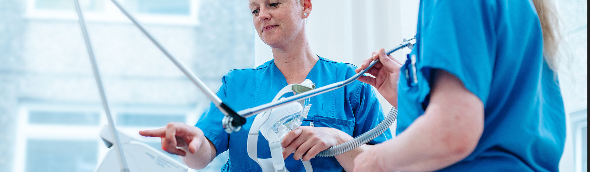 Zwei Pflegefachkräfte halten Beatmungsmaske in der Hand. Zwei Pflegefachkräfte halten Beatmungsmaske in der Hand.