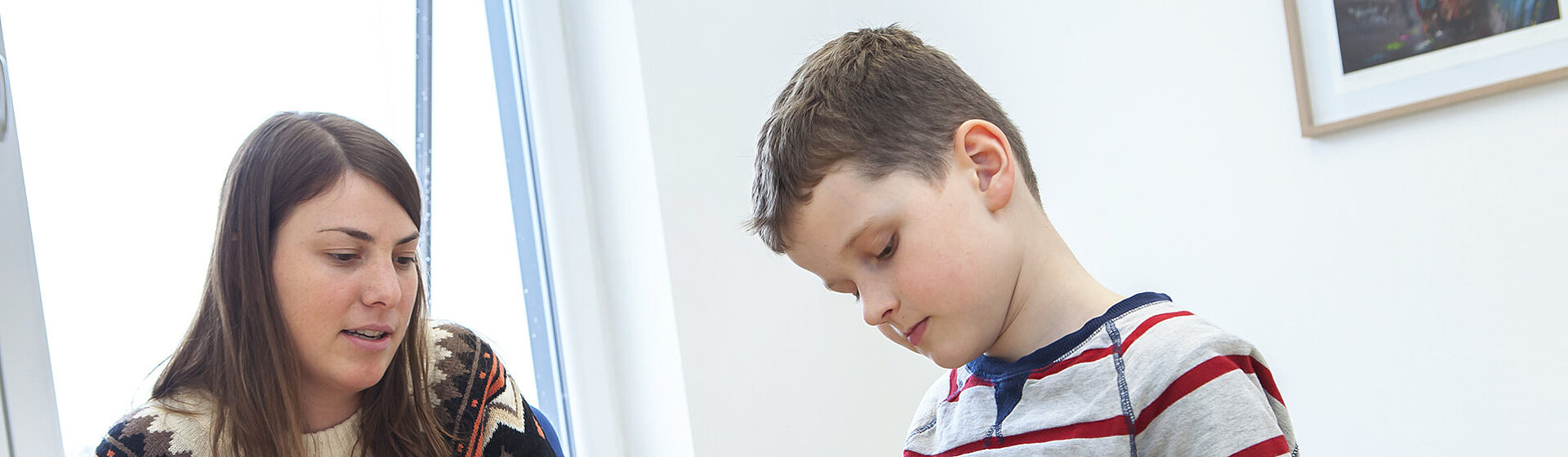 Eine Psychologin unterhält sich mit einem Jungen, der mit Spielzeugfiguren spielt. Eine Psychologin unterhält sich mit einem Jungen, der mit Spielzeugfiguren spielt.