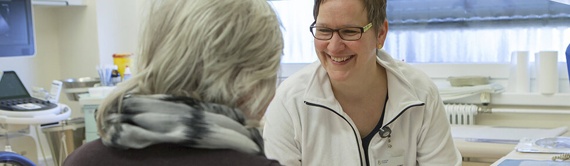 Ärztin lächelt Patientin an.