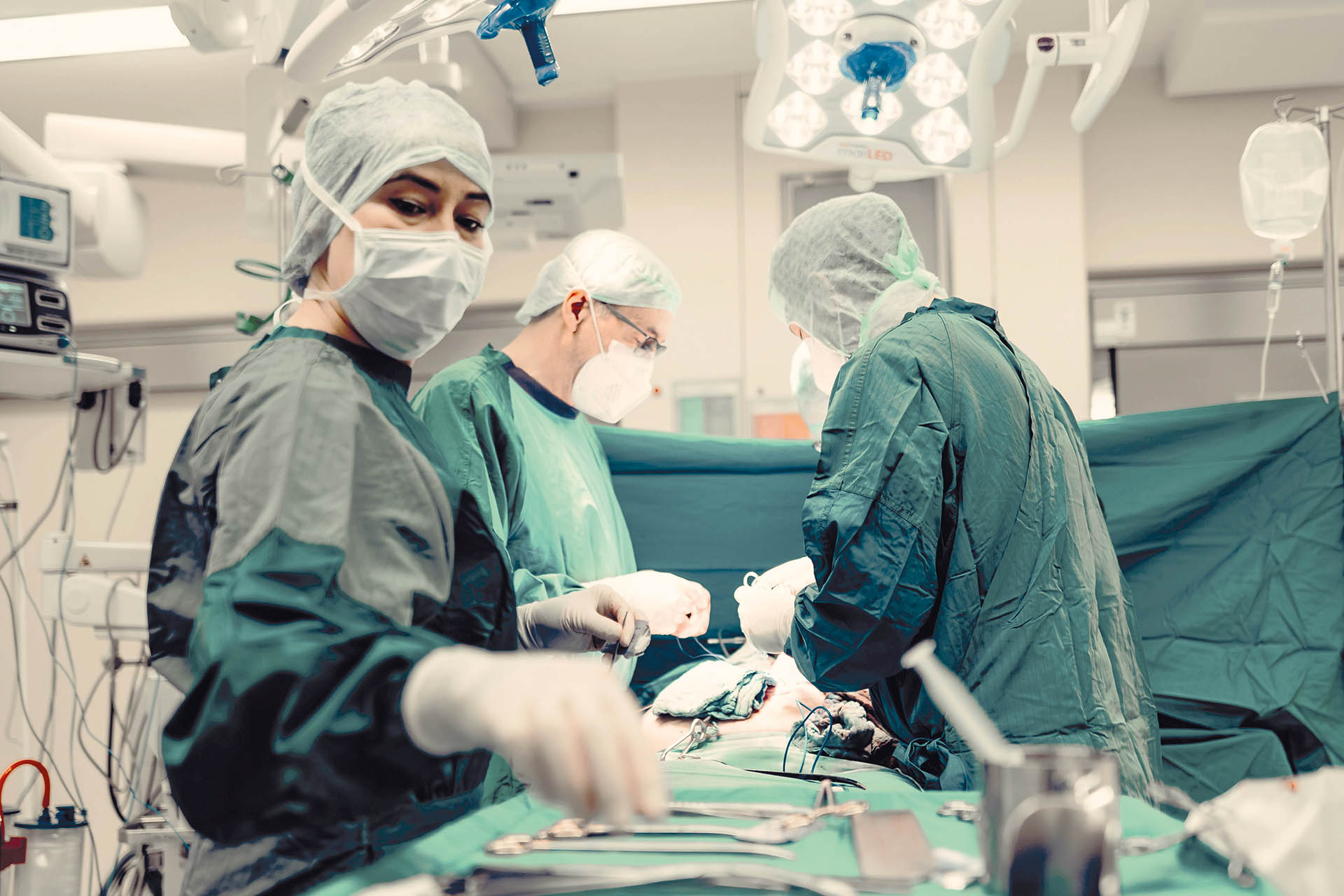Drei MitarbeiterInnen vom medizinischen Fachpersonal während einer OP.